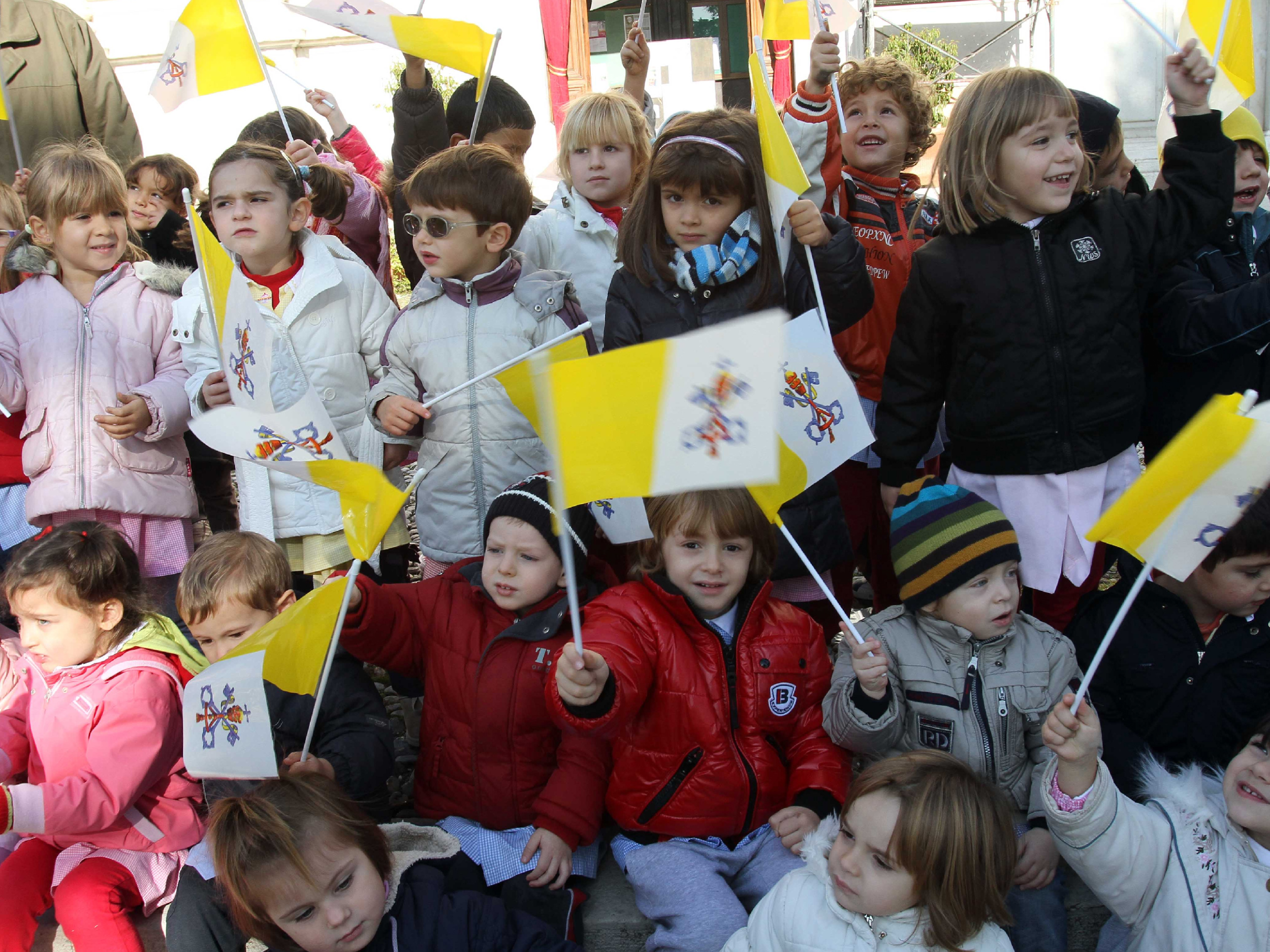 Un gruppo di bambini con le bandierine del Vaticano sul sagrato della Chiesa  di Botticino FOTOLIVE 